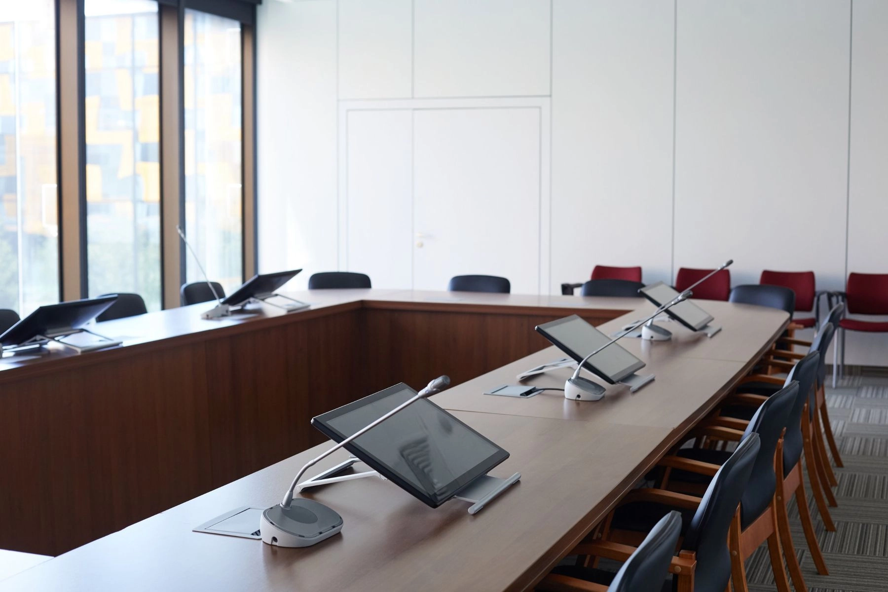 Conference room with gooseneck microphones, seat displays and floor connectivity boxes along the table