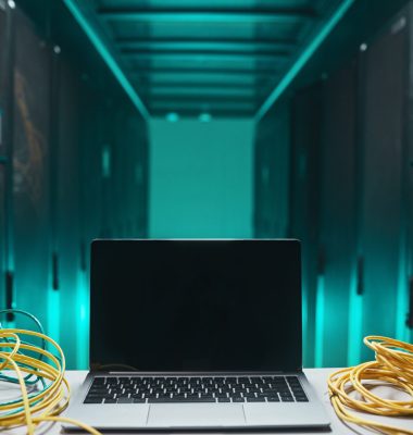 Background image of opened laptop with cables in server room, network maintenance concept, copy space